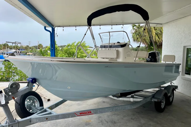 The Image of 2027 Boston Whaler 190 Montauk boat on trailer under a covered area. - 2