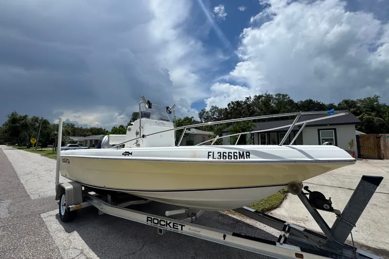Slide: The Image of 2005 Sea Fox 197 Center Console boat on trailer, parked on residential street under cloudy sky. - 4