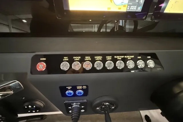 Slide: The Image of Control panel of 2025 Axopar 29 XC Cross Cabin with labeled switches and buttons. - 18