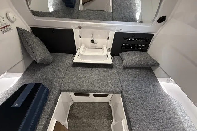 Slide: The Image of 2025 Axopar 29 XC Cross Cabin interior with gray seating and compact sink. - 25