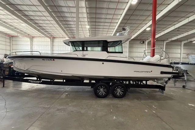 The Image of 2025 Axopar 29 XC Cross Cabin boat on trailer in indoor storage facility. - 0