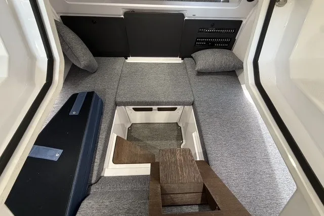 Slide: The Image of 2025 Axopar 29 XC Cross Cabin interior with gray seating and wooden accents. - 24