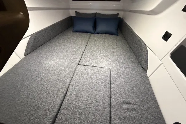 Slide: The Image of Interior cabin of 2025 Axopar 29 XC Cross Cabin with gray bedding and blue pillows. - 28