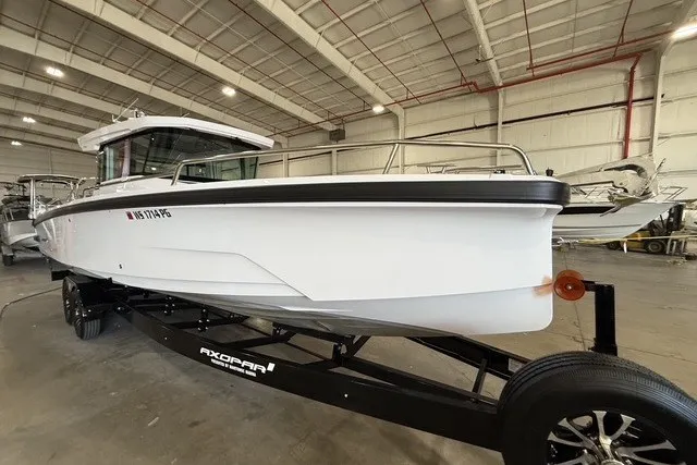 Slide: The Image of 2025 Axopar 29 XC Cross Cabin boat on trailer in indoor storage facility. - 5