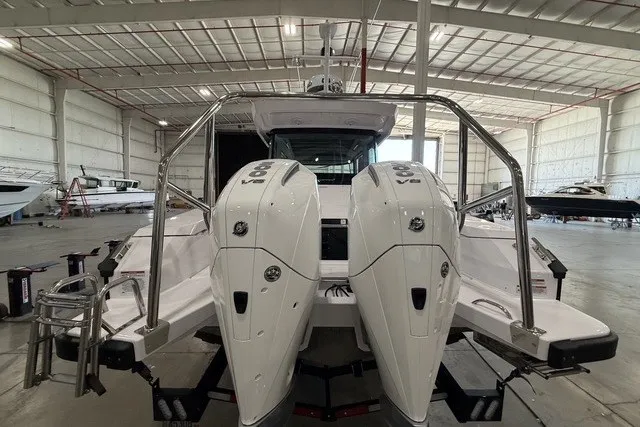 Slide: The Image of 2025 Axopar 29 XC Cross Cabin with dual engines in a spacious indoor marina. - 6