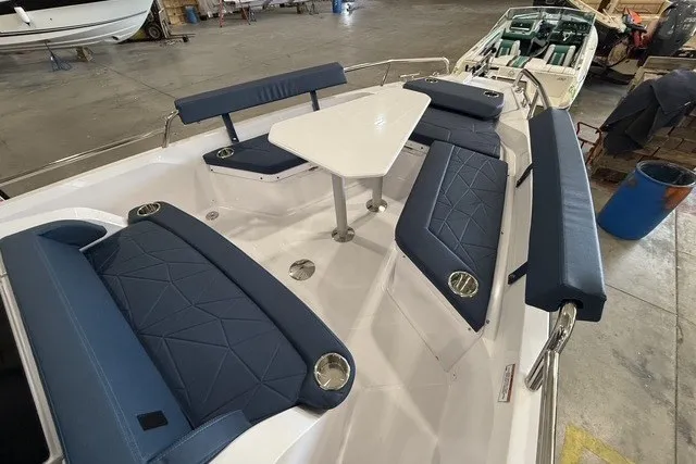 Slide: The Image of 2025 Axopar 29 XC Cross Cabin boat interior with blue seating and central table. - 10
