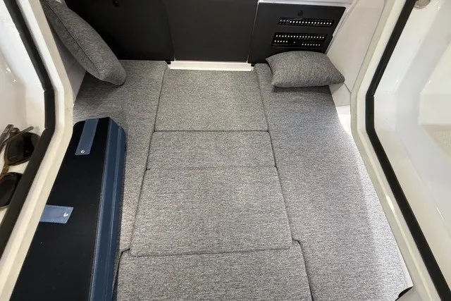 Slide: The Image of 2025 Axopar 29 XC Cross Cabin interior with gray cushioned seating and pillows. - 27