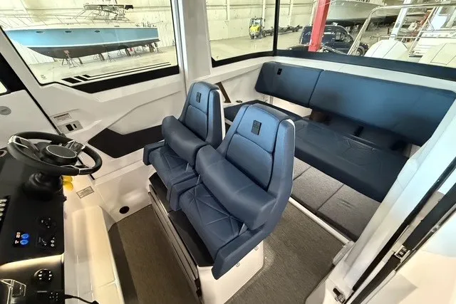 Slide: The Image of 2025 Axopar 29 XC Cross Cabin interior with blue seating and modern dashboard. - 14