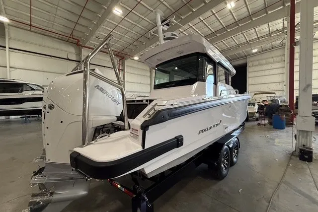 Slide: The Image of 2025 Axopar 29 XC Cross Cabin boat in a warehouse, featuring a Mercury engine. - 4