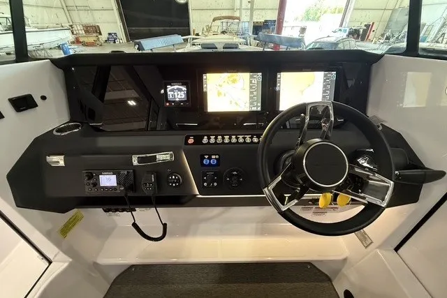 Slide: The Image of 2025 Axopar 29 XC Cross Cabin dashboard with modern navigation and control systems. - 16