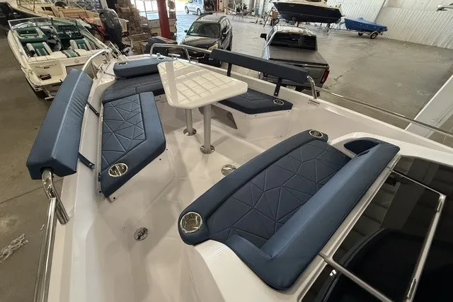 Slide: The Image of 2025 Axopar 29 XC Cross Cabin boat interior with blue seating and central table. - 9