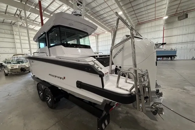 Slide: The Image of 2025 Axopar 29 XC Cross Cabin boat in a spacious indoor showroom. - 3