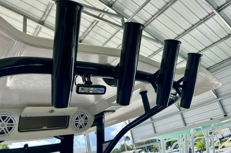 Slide: The Image of Robalo R230 Center Console 2027 with rod holders and speakers under a metal roof. - 17