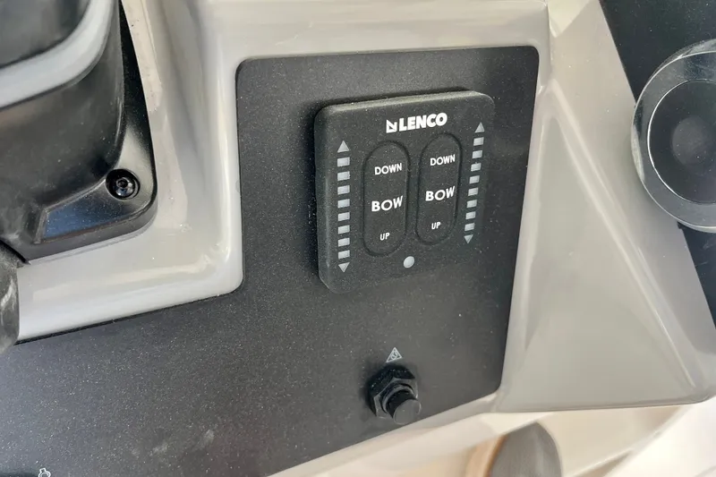 Slide: The Image of Control panel of 2027 Robalo R230 Center Console boat with Lenco trim tab switches. - 24