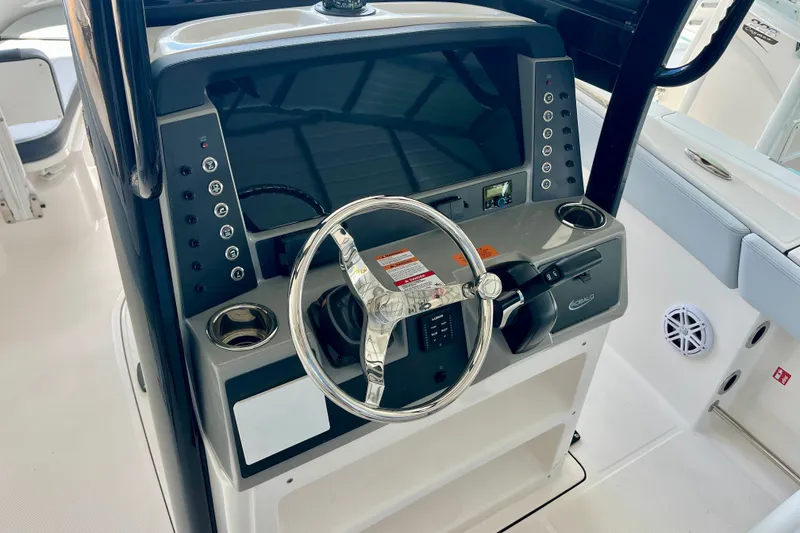 Slide: The Image of 2027 Robalo R230 Center Console boat dashboard with steering wheel and control panel. - 22