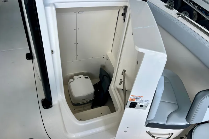 Slide: The Image of 2027 Robalo R230 Center Console boat interior with compact marine toilet. - 28