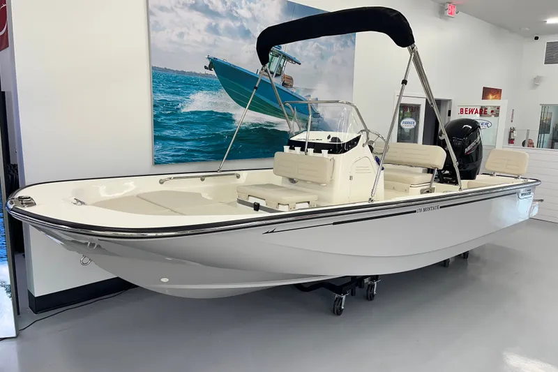 The Image of 2027 Boston Whaler 170 Montauk boat displayed indoors with seating and canopy. - 2