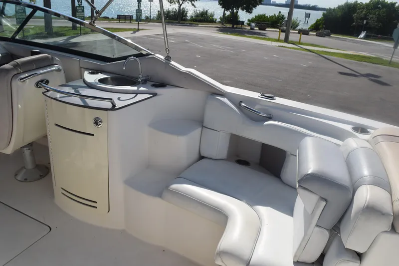 Slide: The Image of 2005 Sea Ray SLX 280 boat interior with seating and sink, near waterfront. - 30