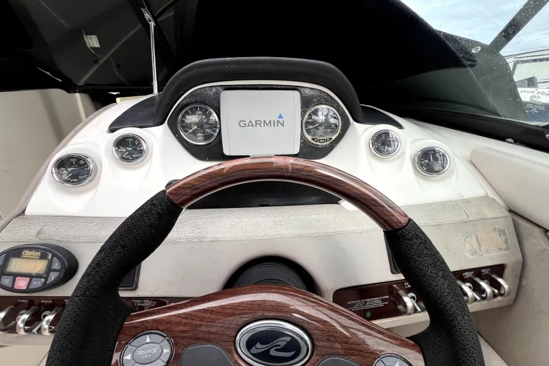 Slide: The Image of 2005 Sea Ray SLX 280 dashboard with Garmin navigation and wood-trimmed steering wheel. - 32
