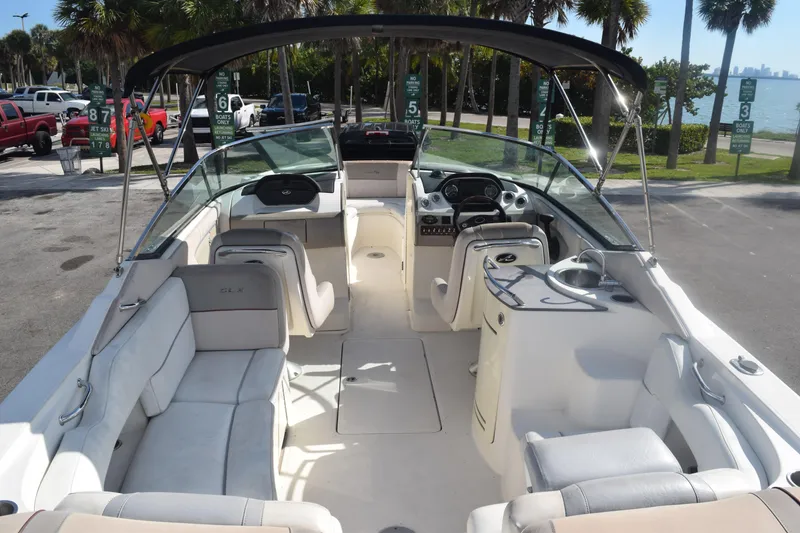 Slide: The Image of 2005 Sea Ray SLX 280 boat interior with seating and helm, parked near waterfront. - 17