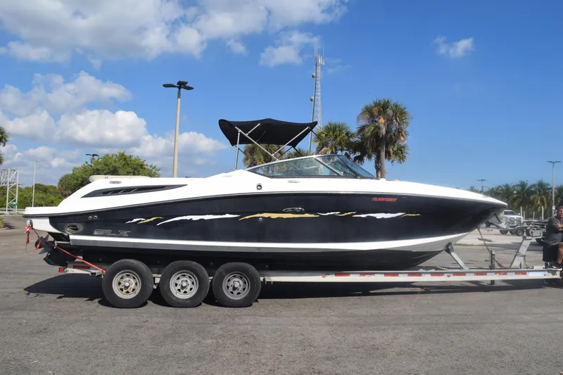 Slide: The Image of 2005 Sea Ray SLX 280 boat on trailer under clear blue sky. - 2