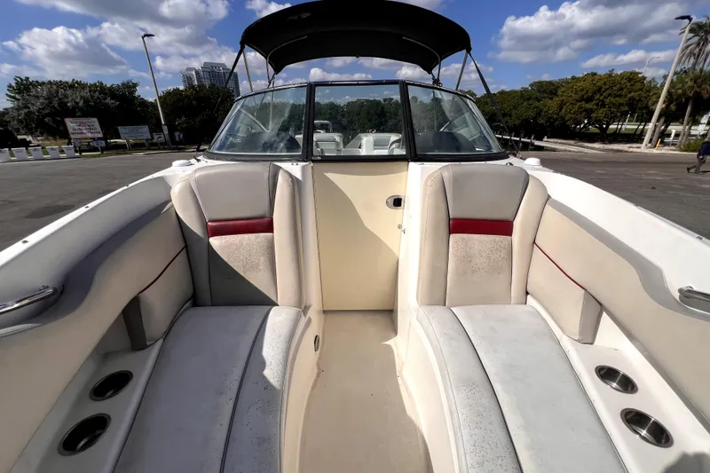 Slide: The Image of 2005 Sea Ray SLX 280 boat interior with white and red seating under a sunny sky. - 22