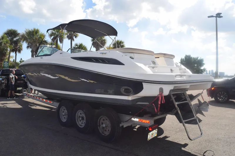 Slide: The Image of 2005 Sea Ray SLX 280 boat on trailer, parked under sunny skies with palm trees. - 5