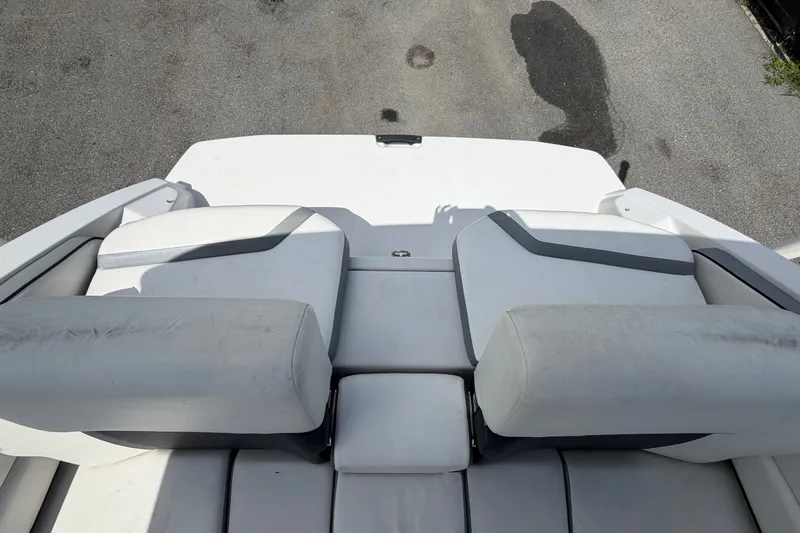 Slide: The Image of Rear seating area of a 2018 Scarab 195 G boat, featuring white and gray upholstery. - 58