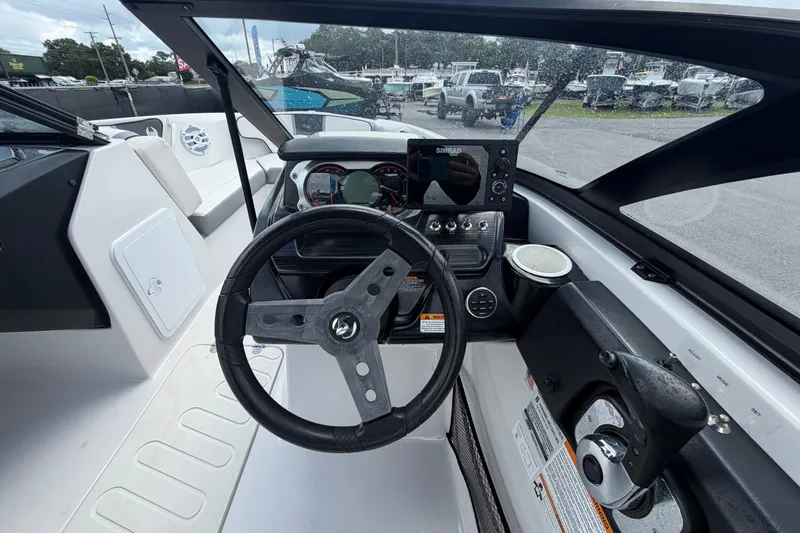 Slide: The Image of Cockpit view of a 2018 Scarab 195 G boat with steering wheel and dashboard controls. - 21