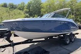 Slide: The Image of 2026 Yamaha Boats SX220 on trailer, blue and white design, parked outdoors. - 8