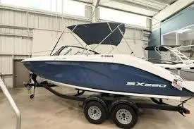 Slide: The Image of 2026 Yamaha Boats SX220 in showroom, blue and white design, on trailer. - 9