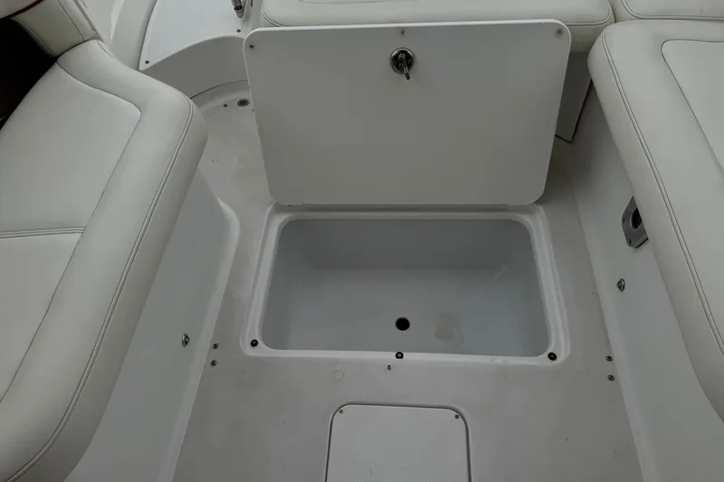 Slide: The Image of 2012 Cobalt 262 WSS boat interior storage compartment with white seating. - 34