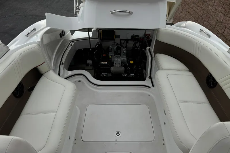 Slide: The Image of 2012 Cobalt 262 WSS boat interior with open engine compartment and white seating. - 27