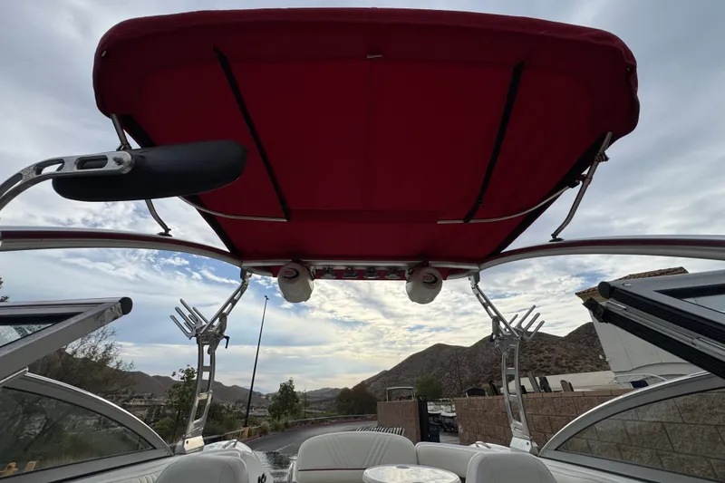 Slide: The Image of 2012 Cobalt 262 WSS boat with red canopy, open seating, and scenic mountain backdrop. - 20