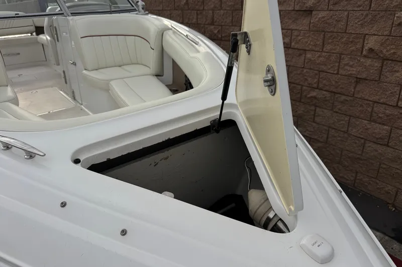 Slide: The Image of 2012 Cobalt 262 WSS boat with open storage compartment and white seating. - 14