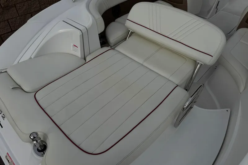Slide: The Image of 2012 Cobalt 262 WSS boat interior with white cushioned seating and red accents. - 9