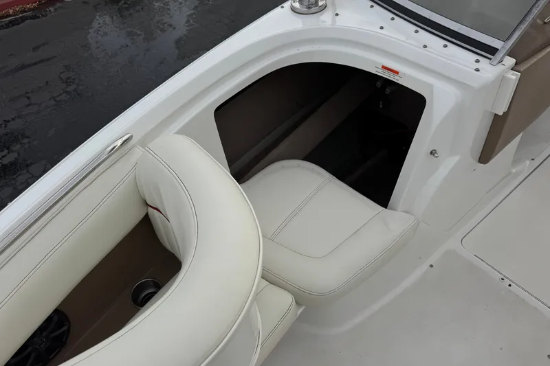 Slide: The Image of Interior view of a 2012 Cobalt 262 WSS boat, featuring white seating and storage compartment. - 18