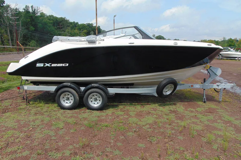 Slide: The Image of 2026 Yamaha Boats SX220 on trailer, sleek black and white design, parked outdoors. - 3