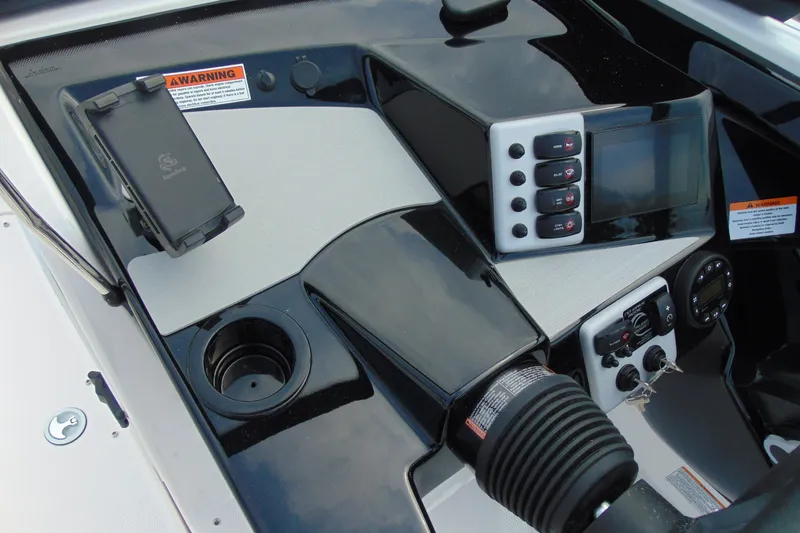 Slide: The Image of 2026 Yamaha Boats SX220 dashboard with controls, cup holder, and warning labels. - 10