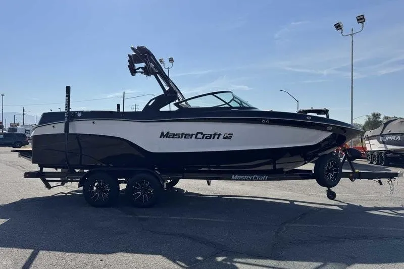 Slide: The Image of 2027 MasterCraft XT23 boat on trailer in outdoor setting. - 13