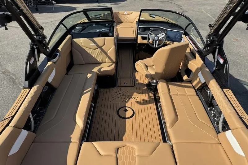 Slide: The Image of 2027 MasterCraft XT23 boat interior with tan seating and modern dashboard design. - 16