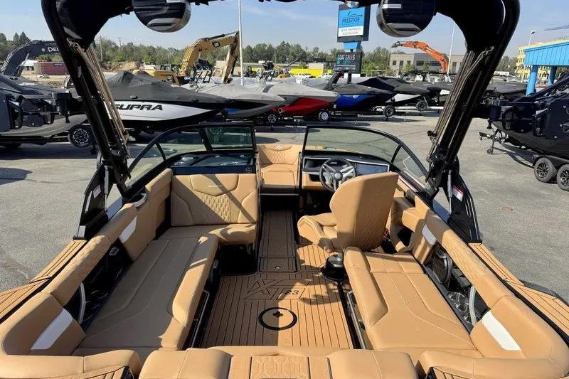 Slide: The Image of 2027 MasterCraft XT23 boat interior with tan seating and modern dashboard. - 14