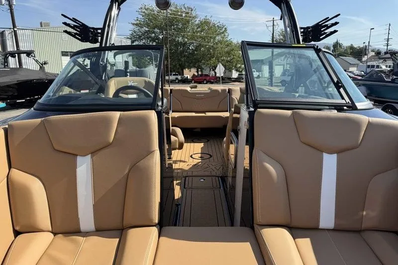 Slide: The Image of 2027 MasterCraft XT23 boat interior with tan leather seats and open windshield. - 15
