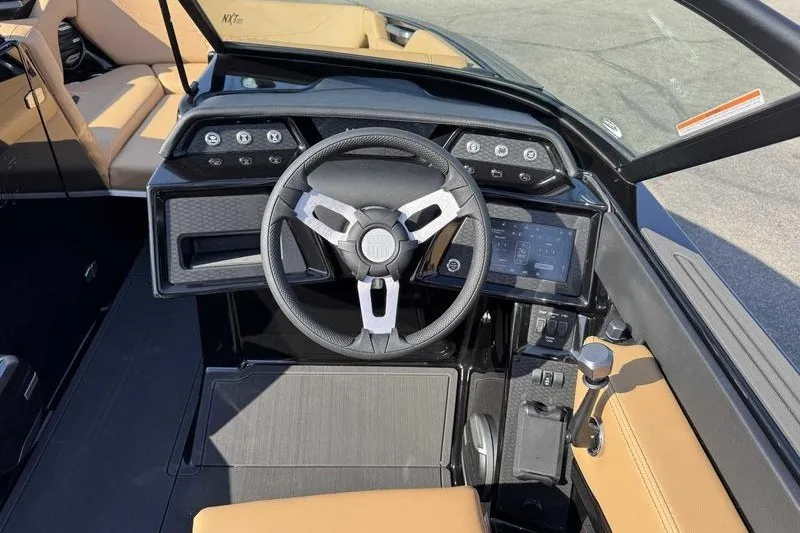 Slide: The Image of 2027 MasterCraft NXT22 boat interior with modern steering wheel and dashboard controls. - 13