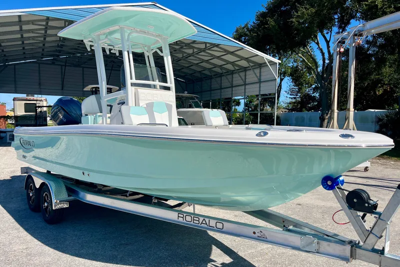 Slide: The Image of 2027 Robalo 226 Cayman boat on trailer under a metal canopy. - 4
