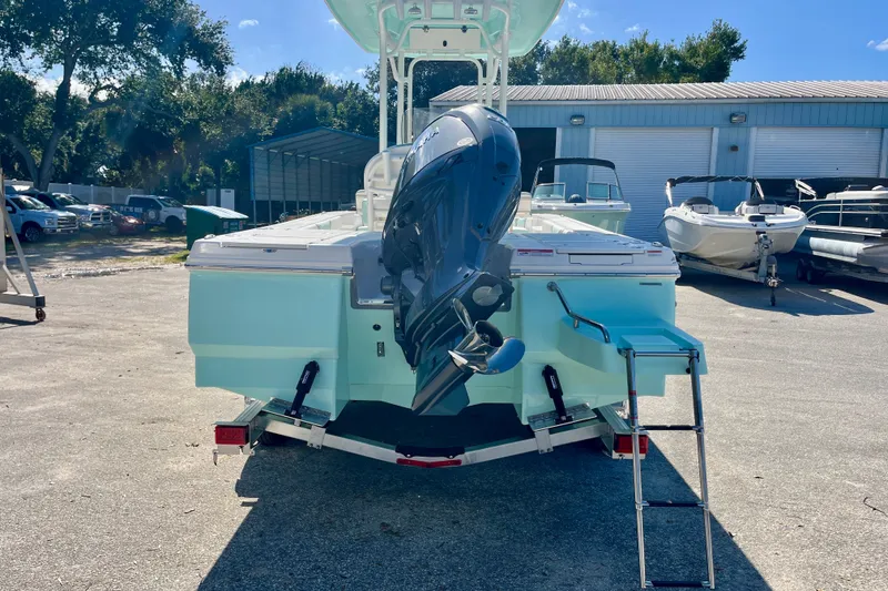 Slide: The Image of 2027 Robalo 226 Cayman boat with outboard motor and ladder, parked outdoors. - 7