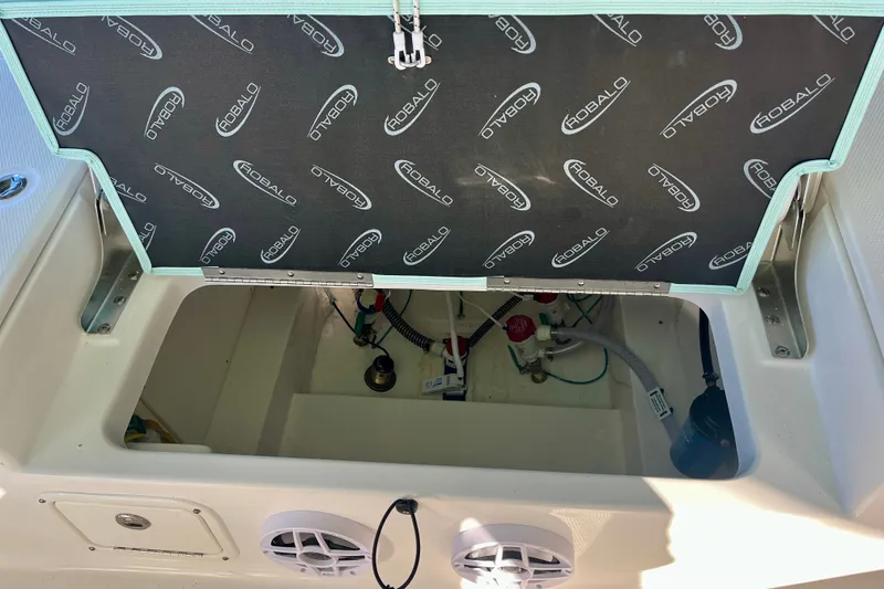 Slide: The Image of Open storage compartment of 2027 Robalo 226 Cayman boat, showing internal wiring and components. - 12