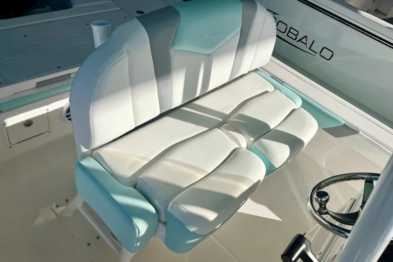 Slide: The Image of 2027 Robalo 226 Cayman boat interior with cushioned seating and steering wheel. - 19