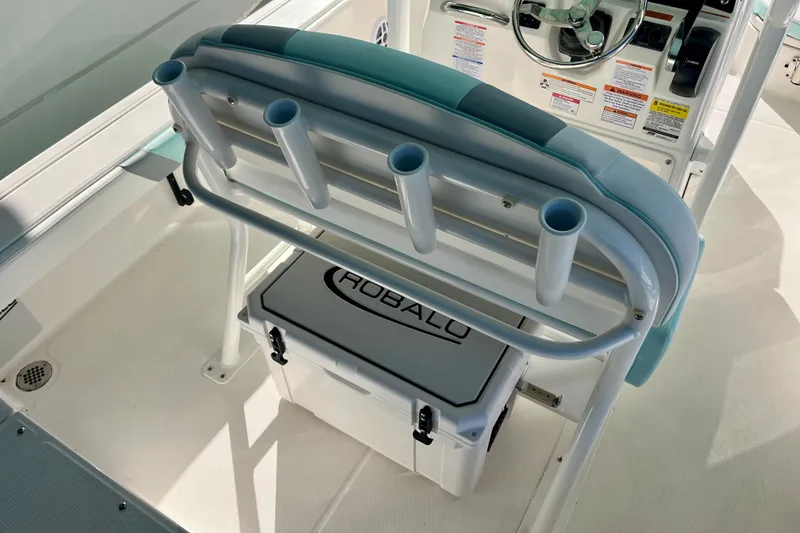 Slide: The Image of 2027 Robalo 226 Cayman boat interior with rod holders and branded cooler. - 13