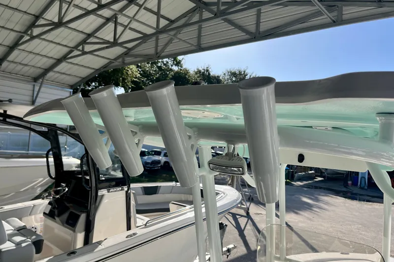 Slide: The Image of 2027 Robalo 226 Cayman boat with rod holders under a canopy. - 14